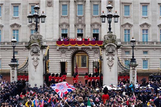 ZUschauer jubeln nach der Krönung von König Charles III. und Königin Camilla vor dem Buckingham Palast in London.