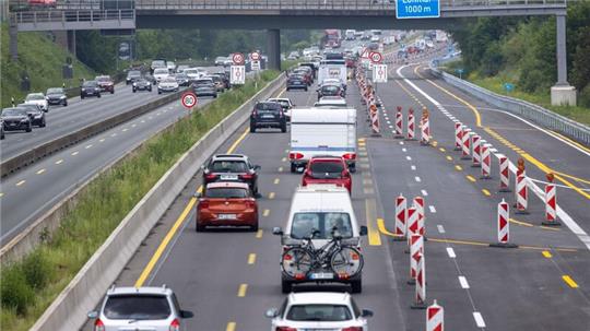 Zahlreiche Autos fahren am Pfingstmontag auf der Autobahn A3 durch eine Baustelle.