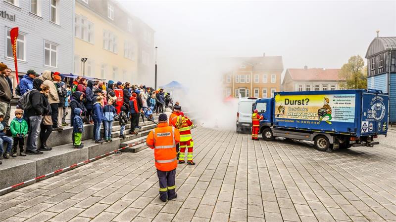 Zahlreiche Besucher sehen zu, wie die Blaulichtfamilie gemeinsam einen Schau-Einsatz bewältigt.