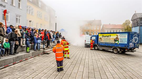 Zahlreiche Besucher sehen zu, wie die Blaulichtfamilie gemeinsam einen Schau-Einsatz bewältigt.
