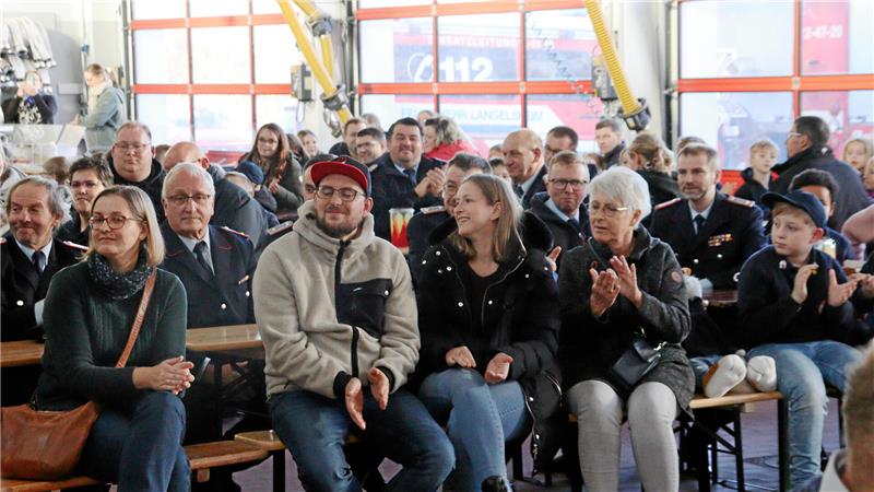Menschen sitzen auf Bänken.