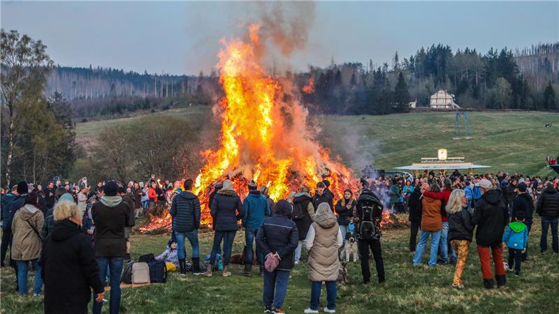 Viele Menschen stehen um das Osterfeuer herum.