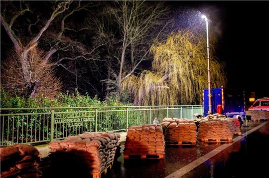 Zahlreiche Sandsäcke stehen auf einer Brücke.