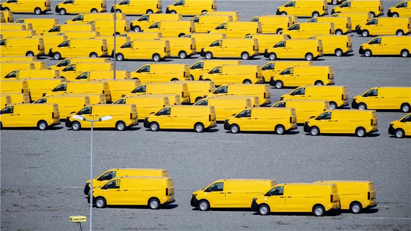 Zahlreiche gelbe Neufahrzeuge vom Typ Volkswagen T7 für die Deutsche Post stehen auf einem Gelände am JadeWeserPort in Wilhelmshaven und werden dort vor Auslieferung zwischengelagert.