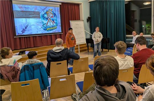 Das Foto zeigt zwei Schüler vor einer beschrifteten Leinwand.
