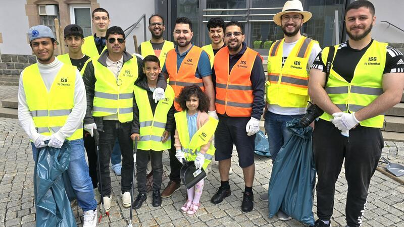 Zehn Männer und zwei Kinder finden sich auf dem Marktkirchenplatz zusammen, um Müll aufzusammeln.