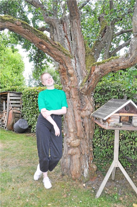 Zeit zum Entspannen: Hannah Löck lehnt im heimischen Dörntener Garten am Pflaumenbaum, der laut ihrem Opa schon 130 Jahre alt ist.  Foto: Heine