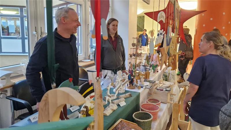 Zimmermann Andreas Basler und Ergotherapeutin Inis Volke verkaufen an einem Stand des Pflegezentrums Holzarbeiten, die während der Therapie entstanden sind.