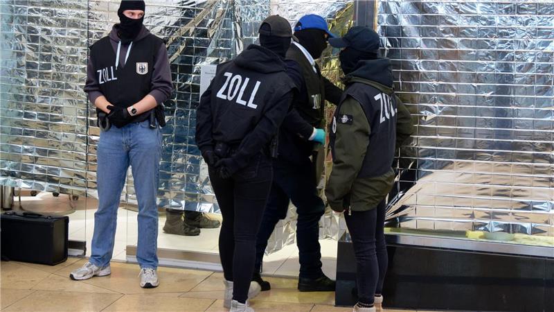 Zollbeamte stehen vor einem Nagelstudio in der Neumarktgalerie in der Innenstadt von Köln.