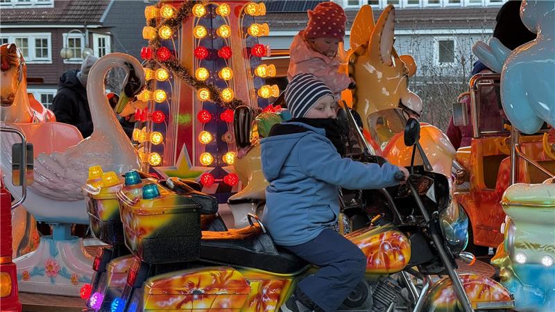 Das Foto zeigt Mädchen und Jungen in einem Kinderkarussell.