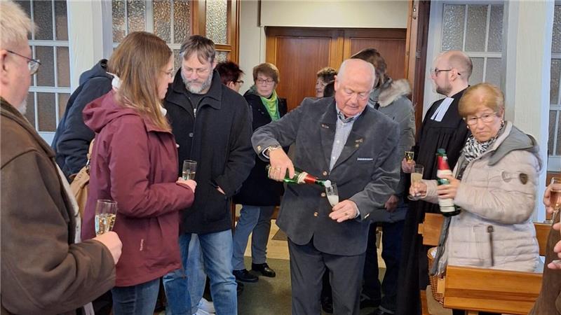 Zum Abschluss gibt es Sekt: Nauens langjähriger Kirchenvorsteher Rüdiger Grund schenkt zur Verabschiedung des alten Kirchenvorstands ein.