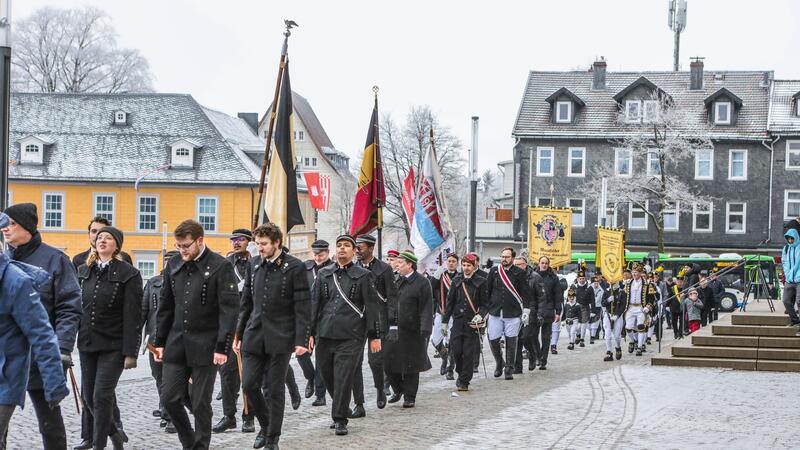 Mehrere Menschen marschieren mit Fahnen.