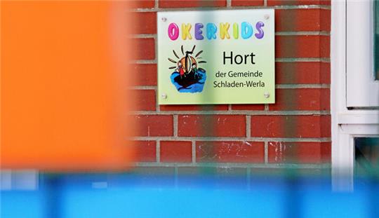 Blick durch einen Zaun auf das Schild des Horts "Oker-Kids".