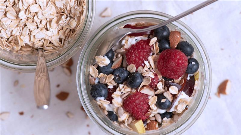 Zum Frühstück Haferflocken mit Nüssen und Beeren: Für Sportler ist eine gesunde und ausgewogene Ernährung entscheidend.