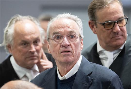 Zum Prozessauftakt gegen die mutmaßliche «Reichsbürger»-Gruppe steht der Hauptangeklagte Heinrich XIII. Prinz Reuß (M) zwischen seinen Verteidigern im Gerichtssaal.