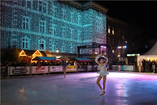 Zwei Eiskunstläuferinnen auf der Eisbahn.
