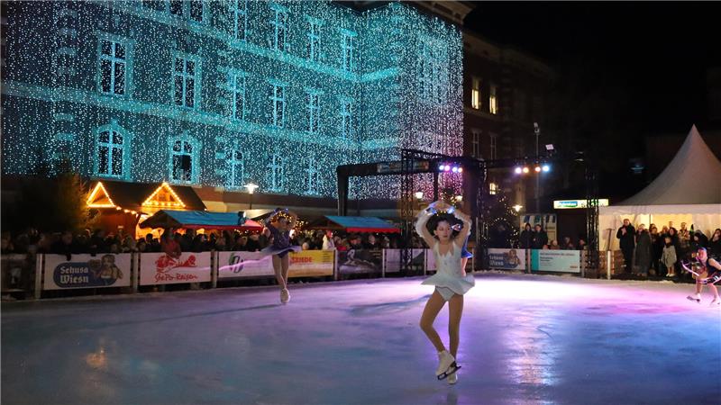 Zwei Eiskunstläuferinnen auf der Eisbahn.