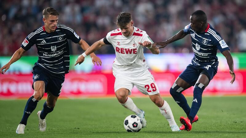 Zum Start in die Zweitliga-Saison lieferten sich der 1. FC Köln um Jan Thielmann  und der Hamburger SV um Miro Muheim (l) und Jean-Luc Dompe (r) eine temporeiche Partie.
