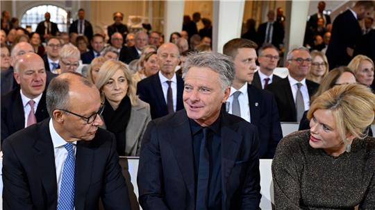 Zum ersten Mal gemeinsam beim Einheitsfest: Bundestagspräsidentin Julia Klöckner (CDU) mit ihrem Lebensgefährten Jörg Pilawa (M.) - im Gespräch mit Bundeskanzler Friedrich Merz (CDU) in der Ludwigskirche.