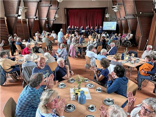 Zur Kaffeetafel tritt auch der Männergesangverein (im Hintergrund) auf, der sein Konzert auch zu einer kleinen Zeitreise durch 75 Jahre Vereinsgeschichte macht. Inklusive einer Bilderreihe aus vergangenen Tagen. Foto: Schlegel