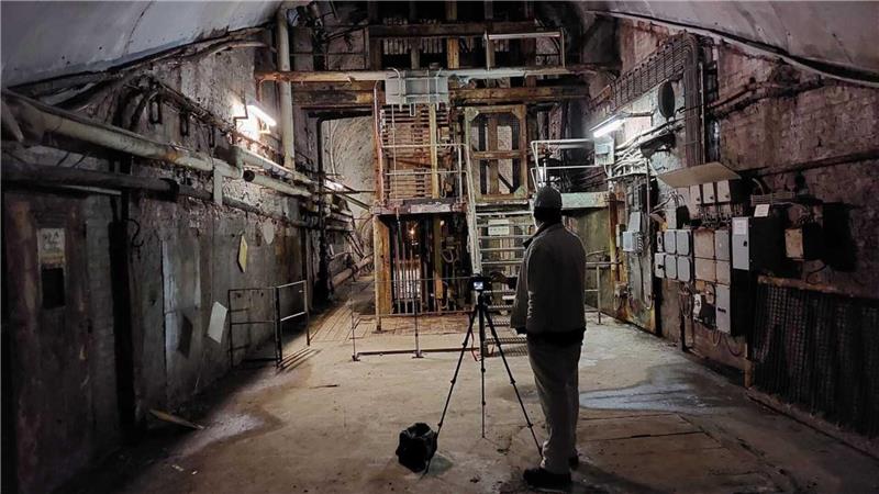 Ein Mann steht mit einer Kamera in einem Raum am Rammelsberg-Museum.