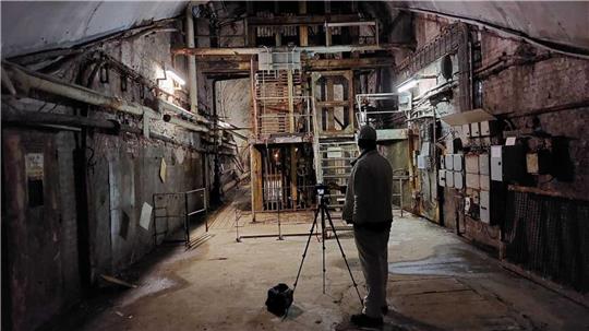 Ein Mann steht mit einer Kamera in einem Raum am Rammelsberg-Museum.