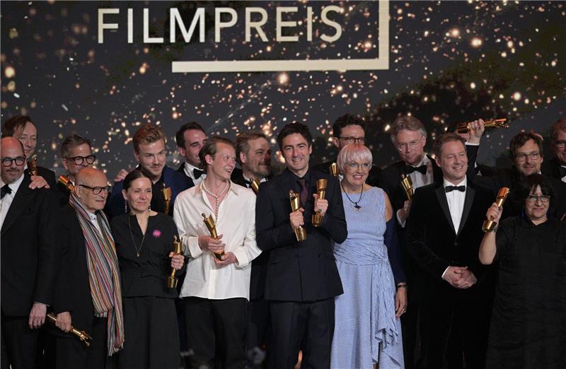 Zusammen mit Kulturstaatsministerin Claudia Roth (im blau-weiß gestreiften Kleid) stehen die Preisträger des Deutschen Filmpreises auf der Bühne.