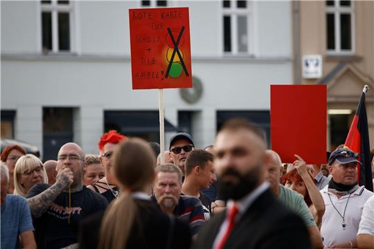 Zuschauer protestieren bei einer Veranstaltung mit Bundeskanzler Olaf Scholz in Neuruppin.