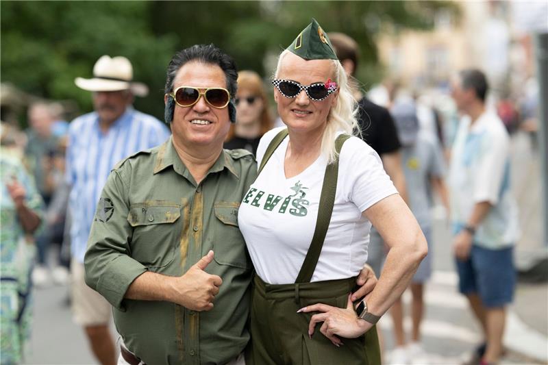 Festival lockt wieder Elvis-Fans nach Bad Nauheim Zwei Besucher des Elvis-Festivals laufen über das Freigelände.