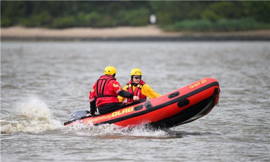 Zwei DLRG-Retter mit einem Schlauchboot auf der Elbe.