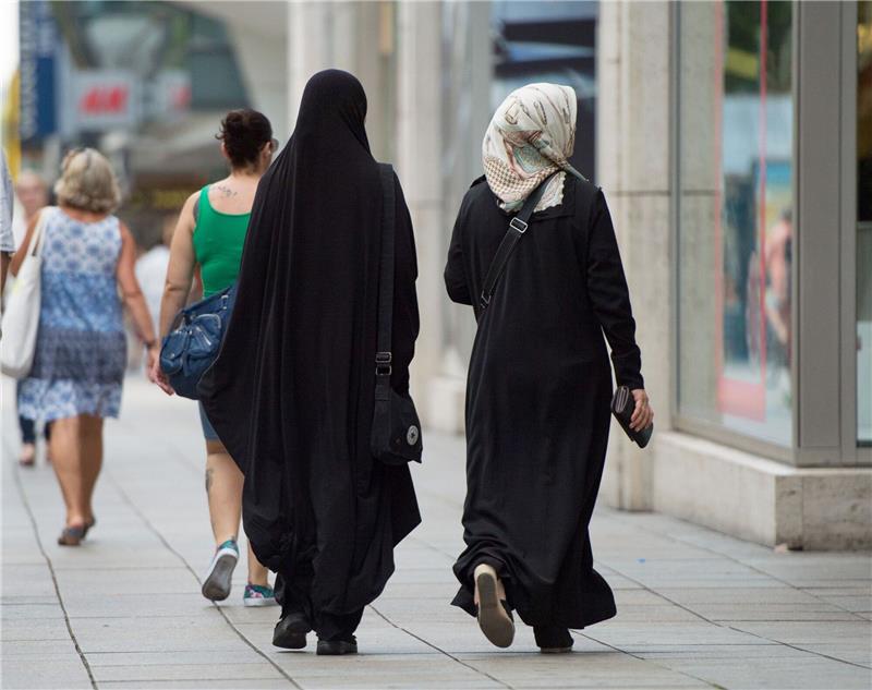 Zwei Frauen mit Kopftuch und langer Oberbekleidung.