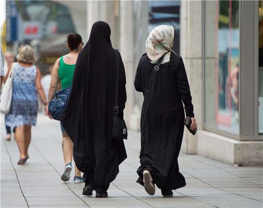 Zwei Frauen mit Kopftuch und langer Oberbekleidung.