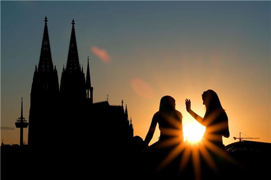 Zwei Frauen vor dem Kölner Dom:  Beim ersten Date verzichten junge Leute nach Tinder-Angaben heutzutage lieber auf Alkohol und treffen sich zu kulturellen Aktivitäten oder draußen statt im Restaurant.