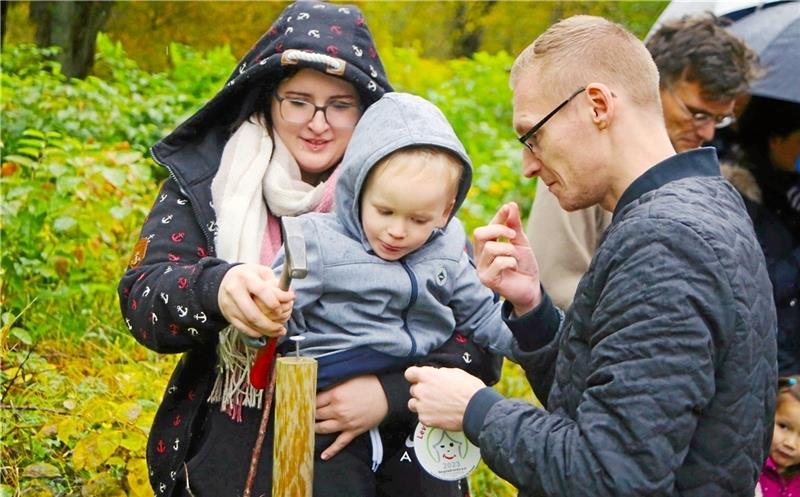 Zwei Jahre alt und schwingt schon den Hammer: Levin Matteo Brait mit seinen Eltern bei der Pflanzaktion in der Babybaum-Allee. Fotos: Jung