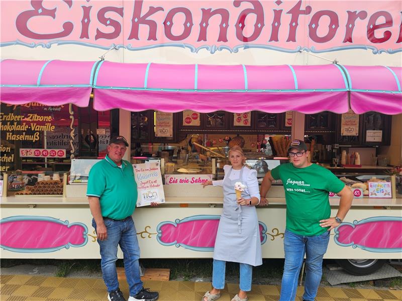 Schützenfest Goslar: Eine neue Generation von Schaustellern Zwei Konrad Ahrends (links der Papa, rechts der Sohn) umrahmen Sarah Brand von Peppis Leckerland. Bei ihr ist nach wie vor das Jubiläumseis von 2022 der Renner. Foto: Sowa