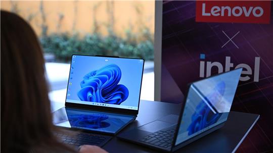 Zwei Lenovo-Laptops, die jeweils zwei Bildschirme haben: Rechts ist der zweite Bildschirm auf der Rückseite des ersten Bildschirms und links sind die beiden Bildschirme nebeneinander montiert - einer liegt vor der Tastatur und dahinter steht der zweite Bildschirm.