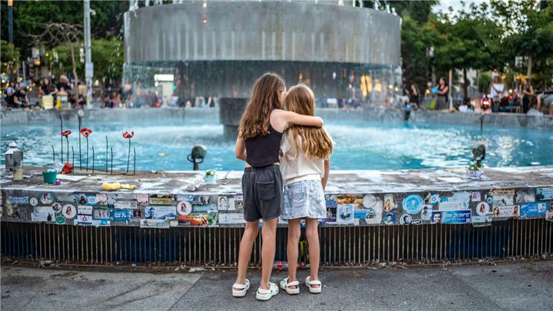 Zwei Mädchen stehen an der Gedenkstätte am Dizengoff-Brunnen in Tel Aviv im Vorfeld des zweiten Jahrestages des Hamas-Anschlags vom 7. Oktober 2023.
