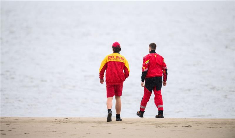 Zwei Mitarbeiter der DLRG an der Elbe.