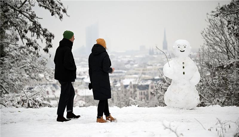 Winteranfang: Glätte und Kälte zum Start in den Dezember Zwei Spaziergänger wandern am Fockeberg an einem Schneemann vorbei.