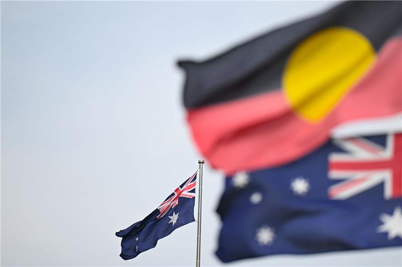 Australien kündigt Referendum über mehr Aborigines-Rechte an Zwei australische und eine Aborigine-Flagge wehen in Canberra.