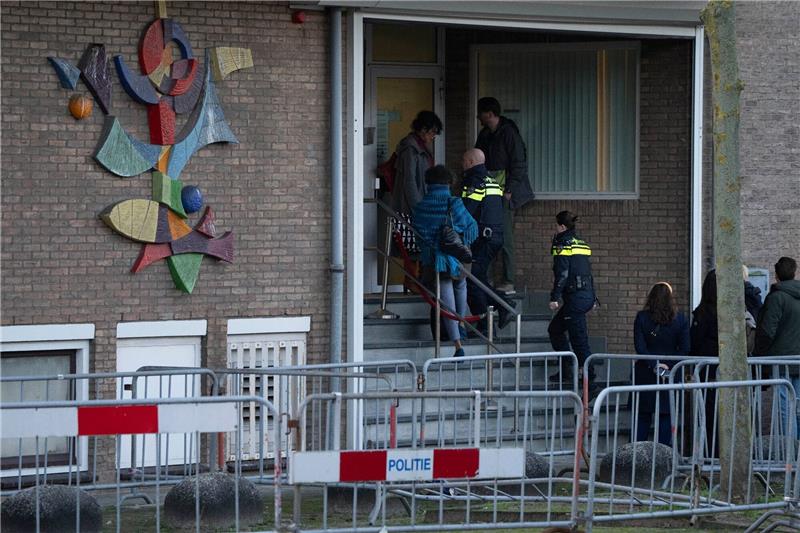 Neun Männer wegen Mordes an Kriminalreporter vor Gericht Zwei niederländische Polizeibeamte betreten das Hochsicherheitsgebäude des Gerichts.