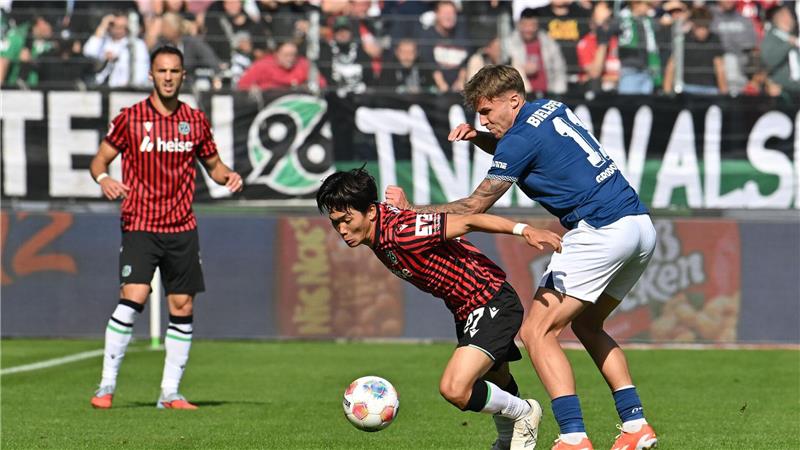 Zweikampf um den Ball: Hayate Matsuda (Hannover 96) wird von Joel Grodowski (Arminia Bielefeld) bedrängt.