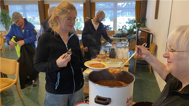 Aus einem riesigen Topf wird Suppe auf einen Teller ausgegeben. 