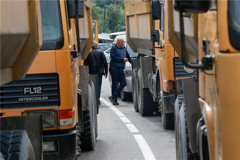 Zwei serbische Männer stehen neben einer Straße, die zum Grenzübergang Jarinje im Norden des Kosovo führt.
