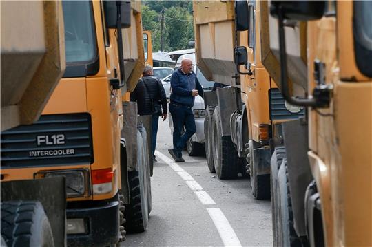 Zwei serbische Männer stehen neben einer Straße, die zum Grenzübergang Jarinje im Norden des Kosovo führt.