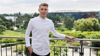 Ein Mann mit Kochkittel schaut in die Kamera.