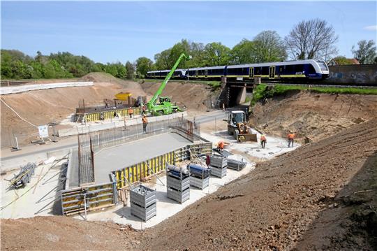 Zwischen beiden Überführungen befindet sich das Baufeld auf der eine der neuen Brücken entsteht. Sie wird das Bauwerk ersetzen, über die gerade der Zug fährt. Foto: Gereke