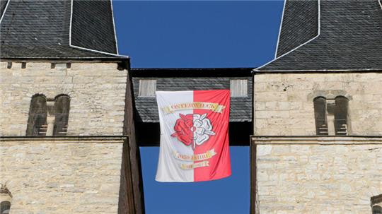 Zwischen den Türmen der Osterwiecker Stephanikirche hängt eine Fahne, die auf das Stadtjubiläum hinweist.