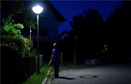 in Junge im Schlafanzug steht nachts mit einem Kissen in der Hand auf einer Straße. Symbolfoto: picture alliance/dpa | Sven Hoppe