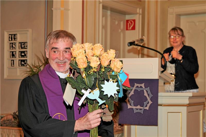 <p>Ein freudiges Lächeln vermag Pfarrer Harald Merz der große Rosenstrauß zu entlocken, den Gemeindemitglieder mit guten Wünschen dekoriert haben. Foto: Leifeld</p>